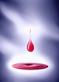 Drop of pink liquid over pool