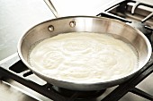 Alfredo Sauce Simmering in a Skillet
