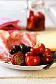 Antipasti platter with stuffed chilli peppers, olives, meat and cheese