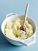 A bowl of mashed potatoes with pepper