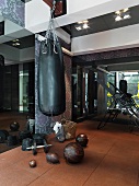 Elegant home gym with punchbag against floral patterned wall and dark mirrors