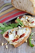 Bruschetta topped with goat's cheese, dried tomatoes and pine nuts