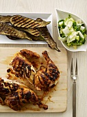 Grilled Chicken on a Cutting Board; Grilled Zucchini; Side Salad