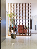 See-through room partition made of spiral battens in a modern living room