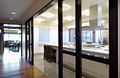Blick durch Glastrennwand auf Küchenblock in moderner Küche