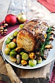 Roast joint of pork on the bone with Brussels sprouts, chestnuts and onions – Christmas roast