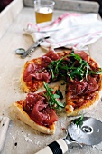Minipizza mit Bresaola und Rucola, angeschnitten