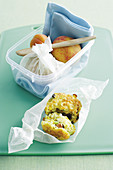 Sweetcorn and cheese muffins with bacon and fruit in a lunchbox