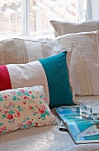 Various striped and floral cushions next to open book on couch