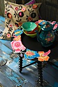 Floral coffee pot on side table with floral motif and cushion with crocheted floral appliqué