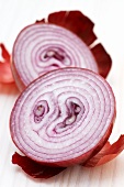 A red onion, halved, with skin