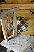 Rustic chair in front of painted farmhouse cupboard