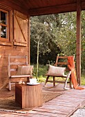 Simple wooden veranda with comfortable rocking chairs and wooden cube as side table
