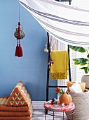 Exotically inspired interior design with lantern and tassels hanging above Thai floor cushions