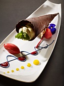 White chocolate mousse in a chocolate wafer served with fruits of the forest sorbet