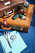 Utensils for converting old suitcases (leather suitcases, cordless screwdriver, spray glue, scissors and screws)