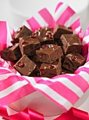 Cranberry and chocolate fudge in a bowl with a pink and white striped napkin
