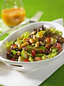 Mixed leaf salad with peanuts, grapes and pears with mango chutney in the background