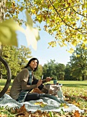 Woman enjoying Autumn picnic under trees