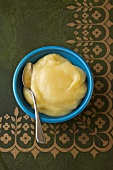 Lemon Curd in a Blue Bowl with a Spoon; From Above