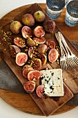 Figs, chopped pistachios and blue cheese on a wooden board