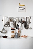 Assorted kitchen utensils on a white wall