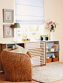 Wicker armchair in front of sideboard with DIY panel of wooden laths mounted in middle