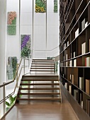 Staircase in modern building with large bookcase alongside of it