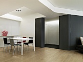 Modern dinette set and a black, gently curved wall in a futuristic looking dining room