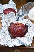 A baked apple with redcurrant jam and walnuts