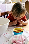 Young girl eating sweets while baking