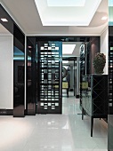 Halbhoher Wandschrank mit schwarz lackierter Front in eleganten Vorraum und Blick in Flur