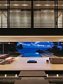 Grandioser Blick in der Abenddämmerung vom offenen puristischen Wohnbereich aus über einen Infinity-Pool auf den Pazifik