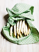 White asparagus wrapped in a tea towel