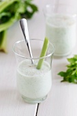 A smoothie garnished with a stick of celery and chives