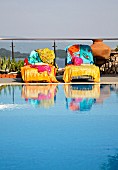 Colourful towels on loungers next to swimming pool on terrace (Villa Octavius, Lefkas, Greece)