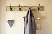 Heart ornament, jacket and lantern hanging from old coat rack