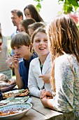 Children standing by the buffet at a garden party