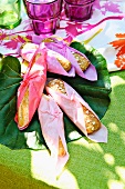 Bread rolls, wrapped in colourful paper napkins, at a summer buffet