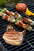 A kebab, a pork chop and grilled vegetables on a coal barbecue