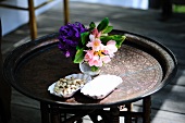 Pistachios and a vase of flowers on a side table