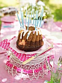 A Nutella birthday cake with candles on a table outdoors