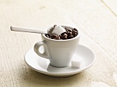 Espressotasse mit Kaffeebohnen und Würfelzucker