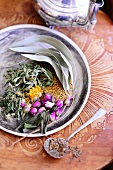 Dried herbs and rose buds with herb tea