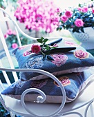 Roses and secateurs on cushions and vintage style, white, metal chair in front of plant pots