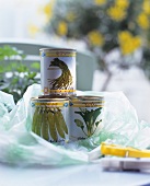 Cans with picture labels featuring vegetables in an open plastic bag