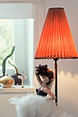 China doll of dancer next to lamp with lampshade