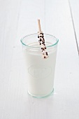 A glass of milk with a chocolate breadstick