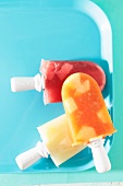 Fruit ice lollies on a blue tray
