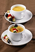 Carrot soup served in cups with vegetable kebabs